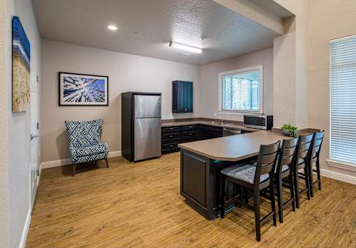 A kitchen with a dining table and chairs.