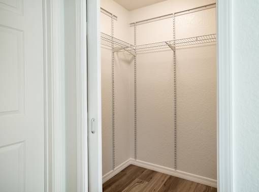A white closet with a door open and shelves.