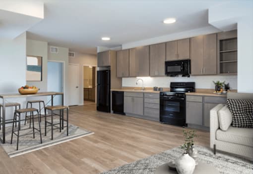 A modern kitchen with wooden floors and a black oven.