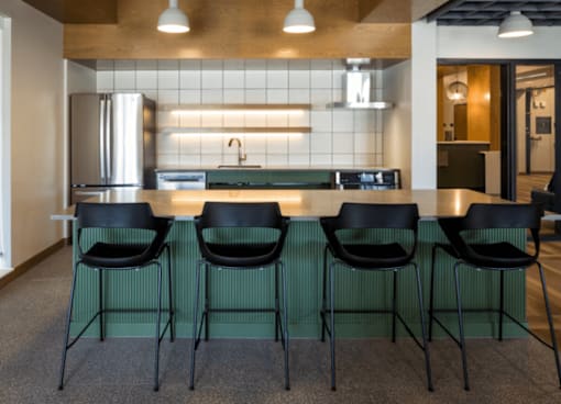 A kitchen with a bar area and four chairs.