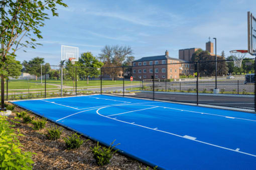 A blue basketball court with white lines and a basketball hoop.