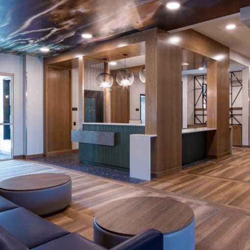 A reception area with a wooden floor and a green reception desk.