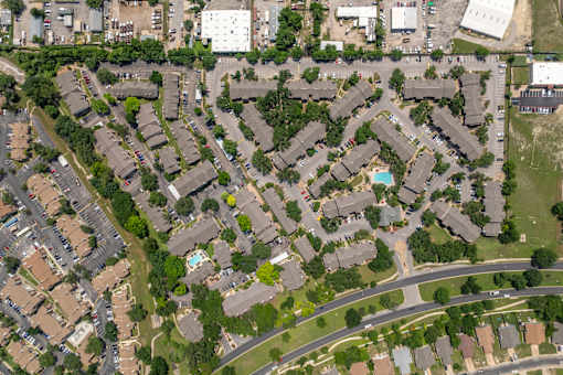 A bird's eye view of a residential area with houses and roads.
