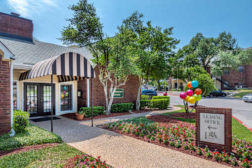 Park at Wells Branch leasing office is located in a landscaped area with a striped awning.