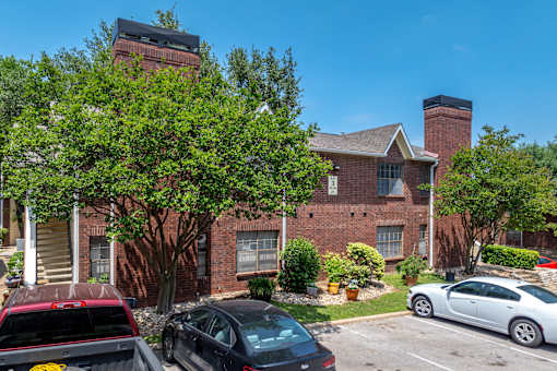A red brick building with a black car parked in front.