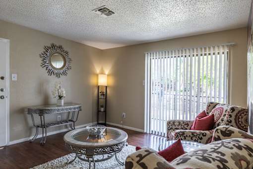 A living room with a glass table and a sofa.