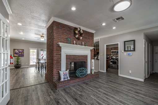 A living room with a fireplace and a ceiling fan.