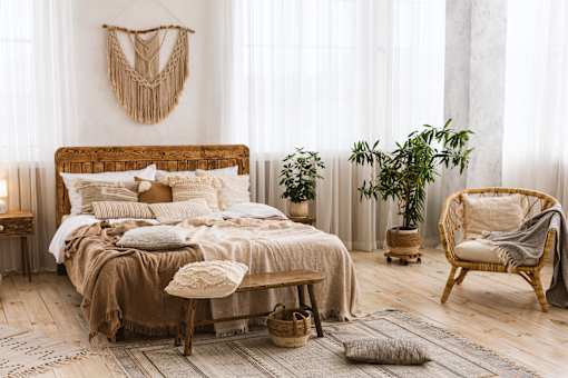 A bedroom with a large bed and a chair.