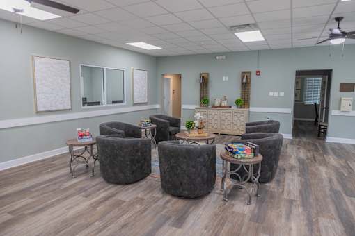 A room with grey chairs and a wooden floor.