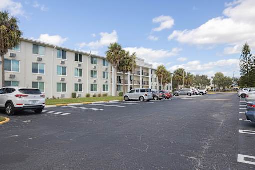 A parking lot with cars and a building in the background.