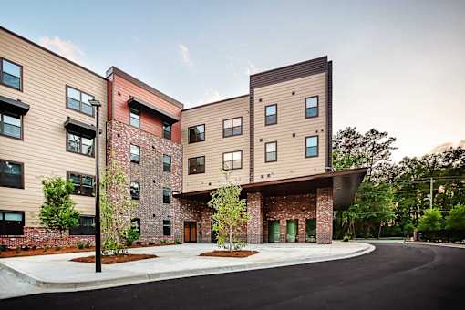 A modern apartment complex with a mix of brick and panel siding.