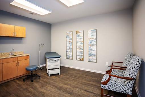 A medical room with a chair and a table.