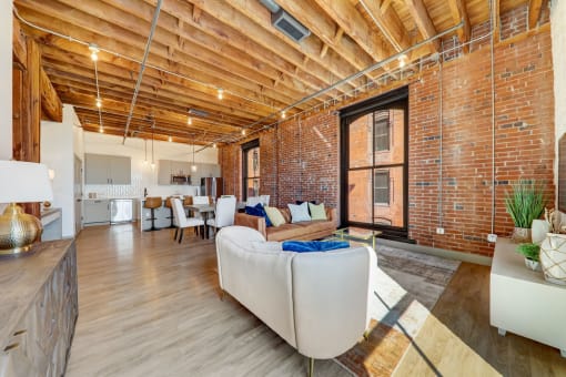 a living room with wooden floors and exposed brick walls