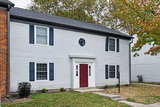 A house with a red door and a grey siding.