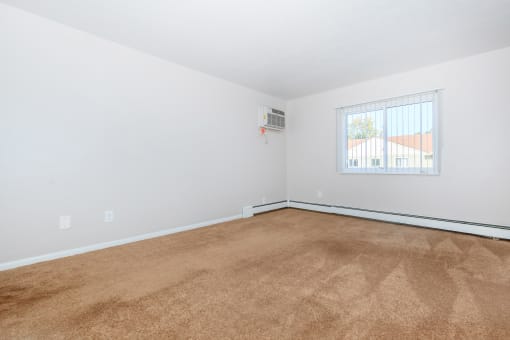 a bedroom with white walls and a window