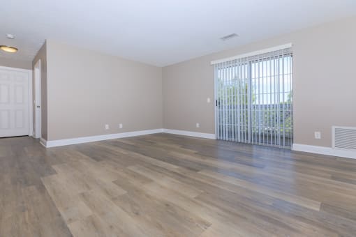 a bedroom with hardwood floors and a large window