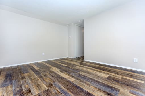 a bedroom with hardwood floors and white walls