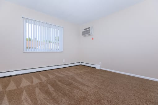 a bedroom with a carpeted floor and a large window