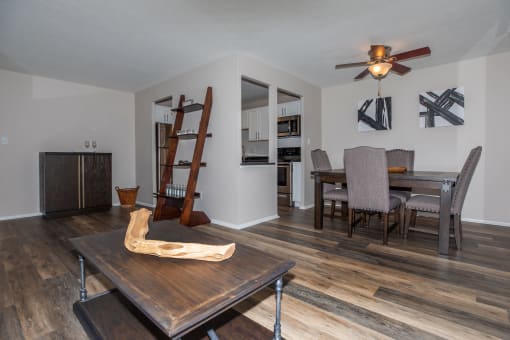 a living room and dining room with hardwood floors and a ceiling fan