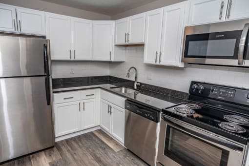 a kitchen with white cabinets and stainless steel appliances