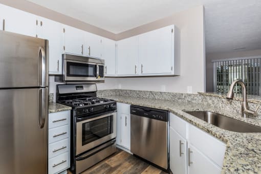 a kitchen with granite countertops and stainless steel appliances