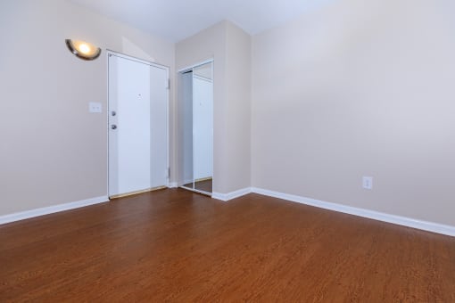 a bedroom with hardwood floors and white walls