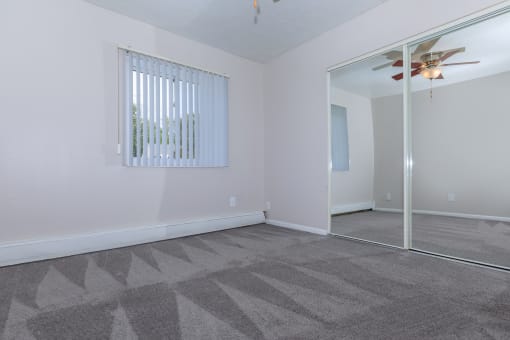 a bedroom with a mirror and a ceiling fan