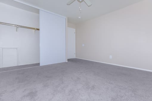 a bedroom with a closet and a ceiling fan