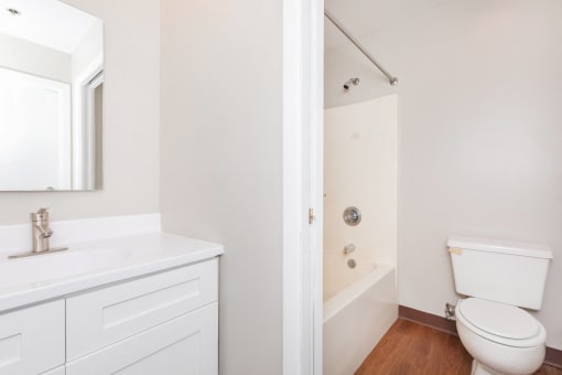 a bathroom with a toilet sink and tub and a mirror