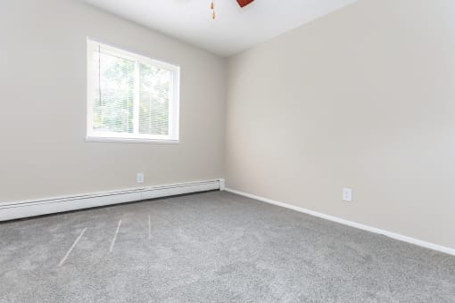 a bedroom with gray walls and a white window