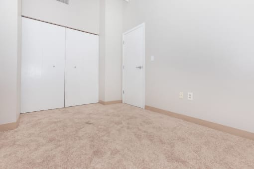 a room with carpet and white walls and doors