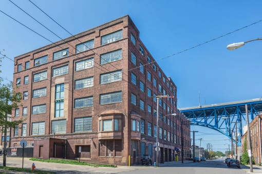 a large brick building with a bridge in the background
