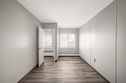 an empty room with white walls and a wood floor