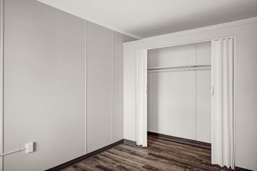 an empty room with white walls and a sliding closet door