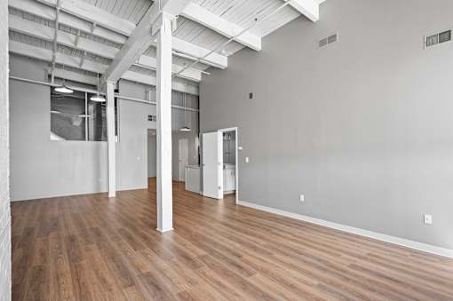 A large empty room with wooden floors and white walls.