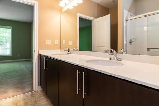 A bathroom with a green wall and a white counter.
