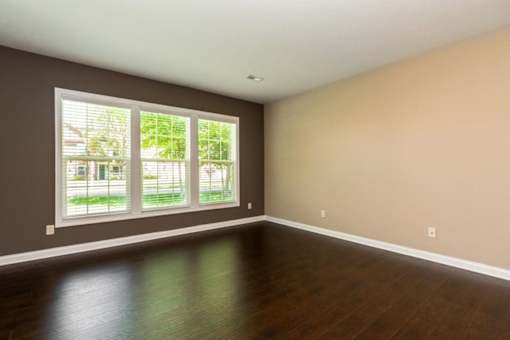 A room with a large window and wooden flooring.