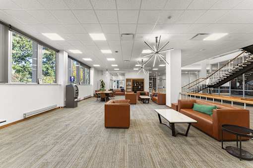 A spacious room with wooden floors and furniture.