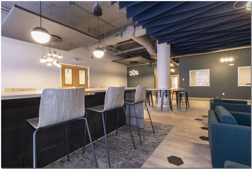 a bar area with stools and tables
