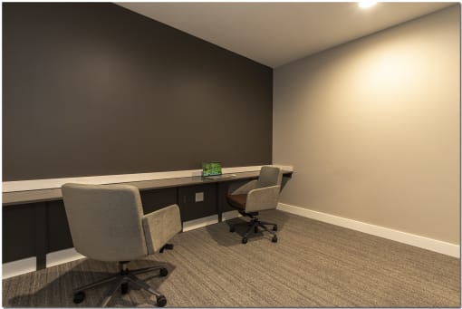 a small office with two desks and two chairs