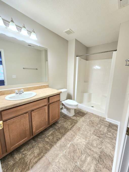 A bathroom with a sink, toilet, and shower.