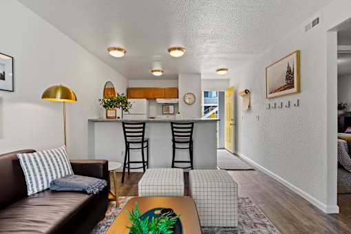 A living room with a brown leather couch and a gold floor lamp. at Vivo Toledo Apartments, Toledo, OH