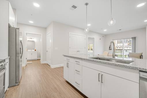 A modern kitchen with white cabinets and a wooden floor. at Park Lamont Townhomes Apartments, Cleveland, OH