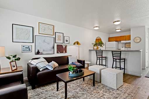A living room with a brown couch, a coffee table, and a striped pillow. at Vivo Toledo Apartments, Toledo, OH, 43607