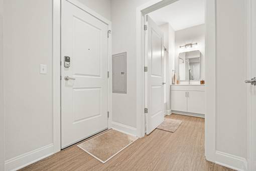 A white door with a silver handle and a doorknob is in a room with a wooden floor. at Park Lamont Townhomes Apartments, Ohio, 44106
