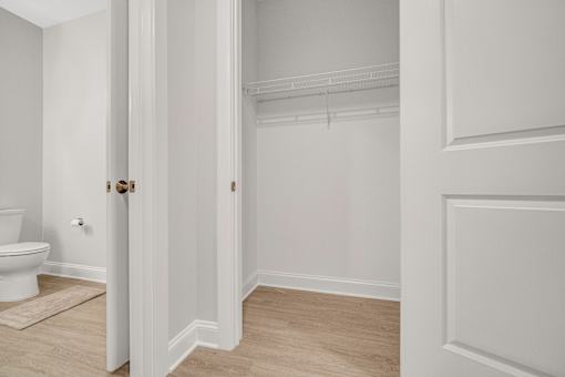 A white bathroom with a toilet and a door. at Park Lamont Townhomes Apartments, Cleveland, OH, 44106