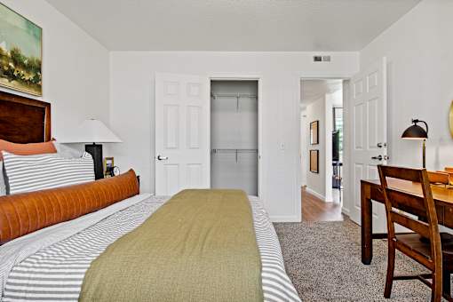 A bedroom with a bed, a chair, and a painting on the wall. at Vivo Toledo Apartments, Toledo