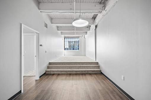 A long hallway with a door on the left and a window on the right.