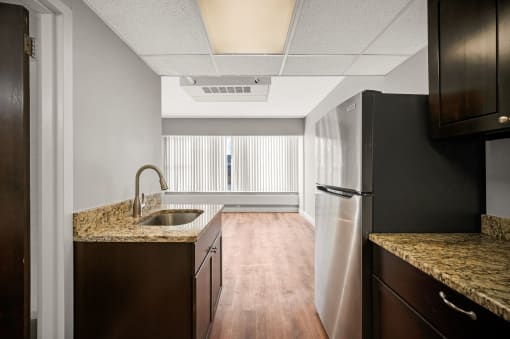 an empty kitchen with a sink and a refrigerator