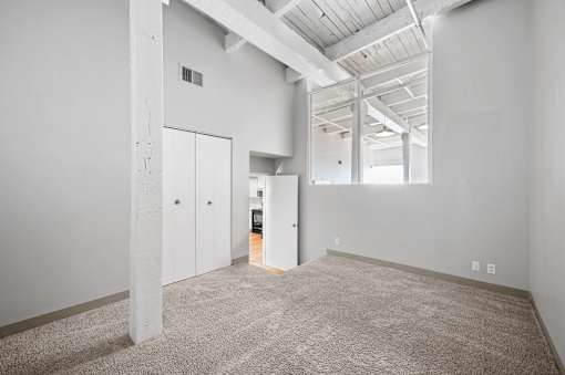 A large, empty room with a carpeted floor and white walls.